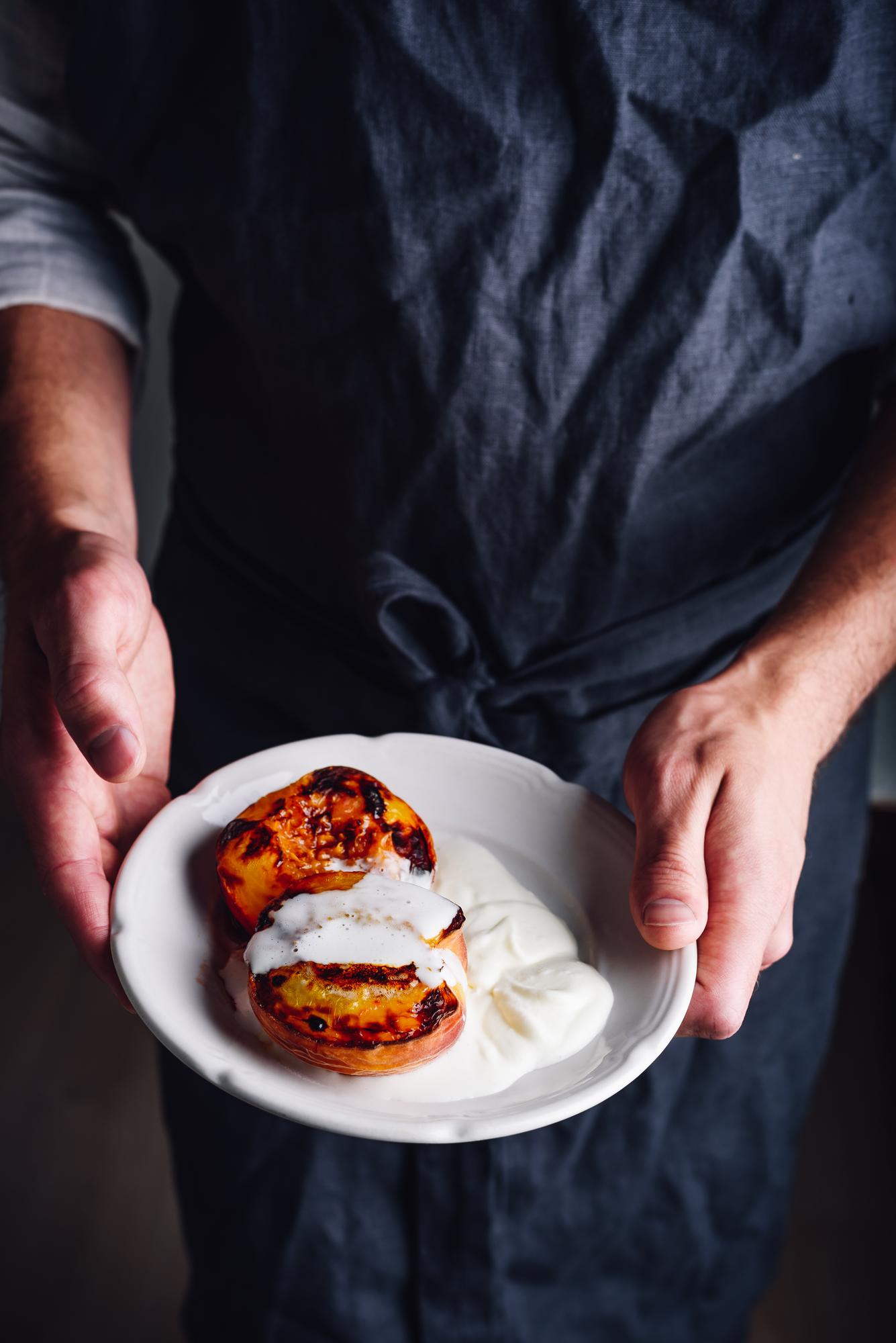 Chef demonstrating plated dish in calm studio